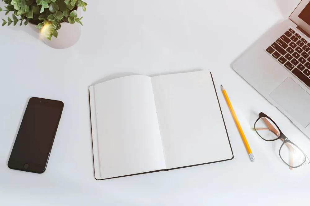 Carnet et ordinateur sur un bureau, image d’illustration